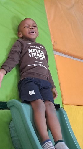 A cheerful child relaxing on the indoor play slide