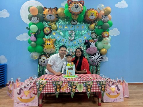 A birthday celebration with a balloon arch and family
